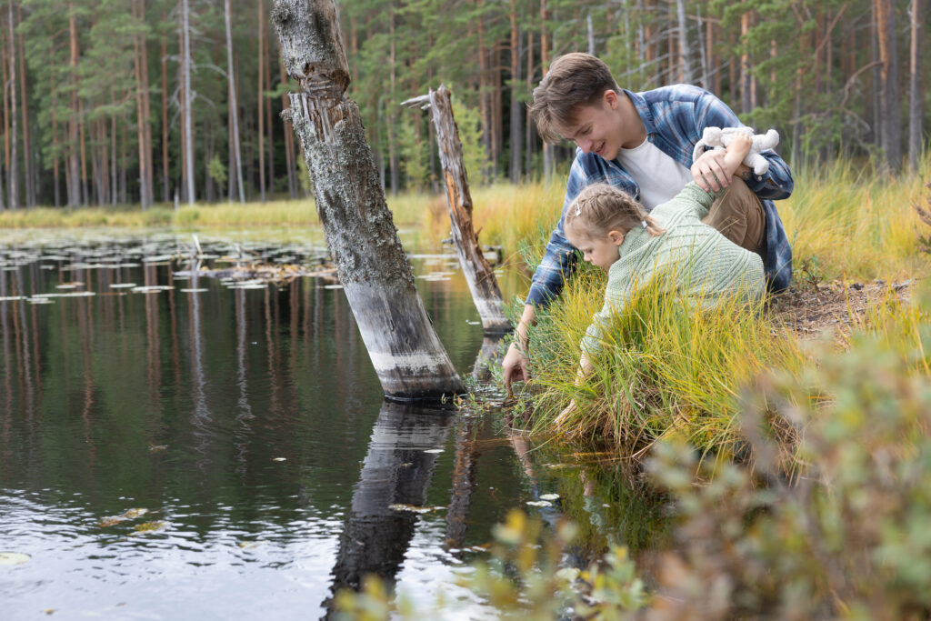 nuori mies ja pieni tyttö kurkistamassa suolampeen Luutasuolla Lopella